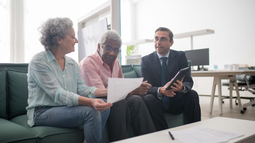 Older couple reviewing a document with an advisor on a couch